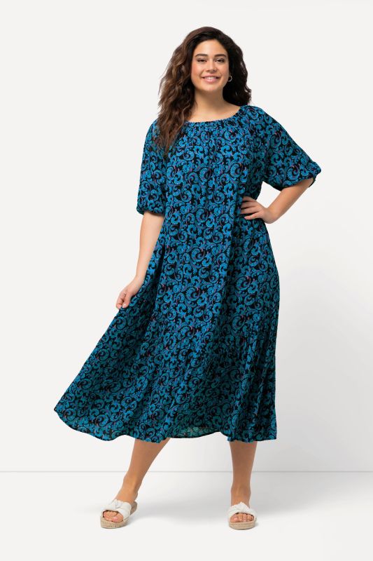 Robe midi à col rond et manches courtes. Volant à la base et motif vrilles