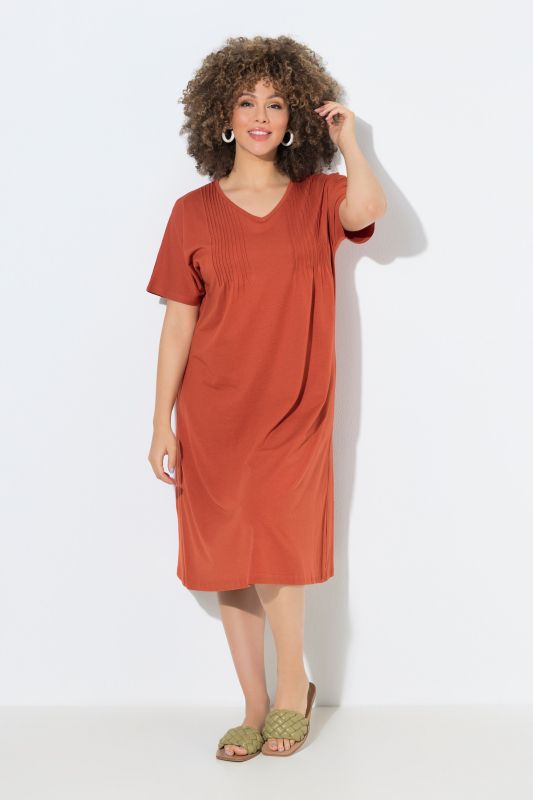 Robe en jersey à plis fantaisie. Col V et manches courtes. Coupe évasée