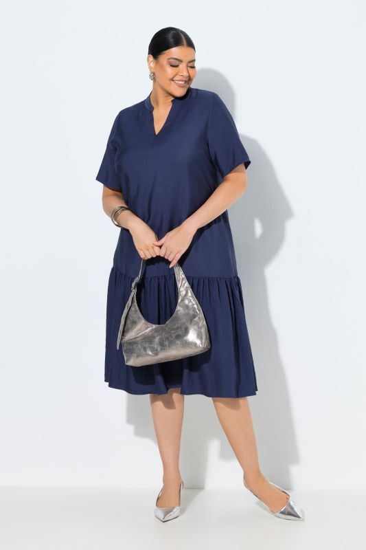 Robe midi, coupe évasée. Manches courtes et col en V. Volant à la base