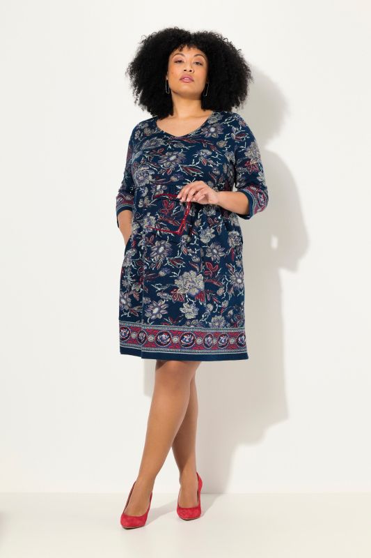 Robe en jersey à fleurs, coupe évasée. Décolleté en V et manches 3/4.