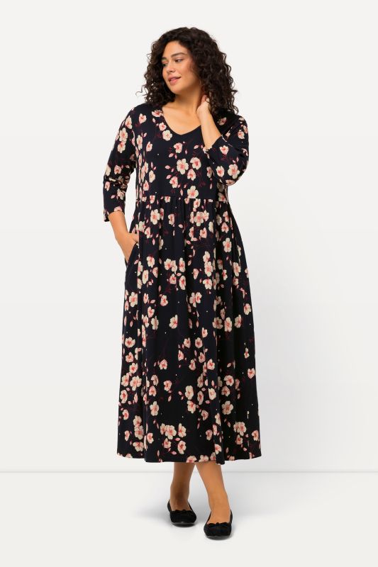 Robe en jersey, col en V et manches 3/4. Motif à fleurs. Ligne en A.