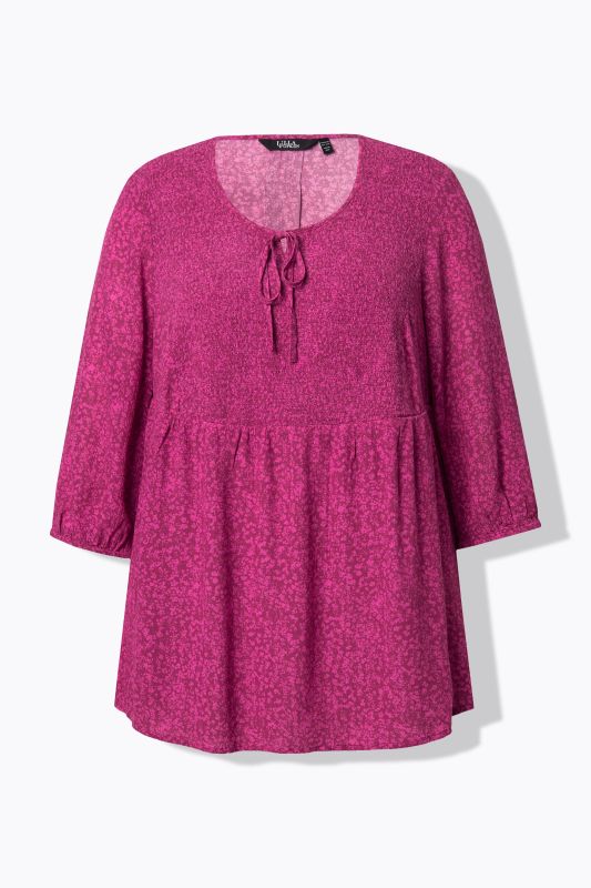 Blouse smockée à pois, avec décolleté rond et manches 3/4. Silhouette en A.