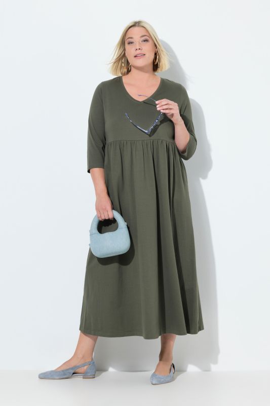 Robe en jersey, couture empire. Décolleté en V et manches 3/4. Poches