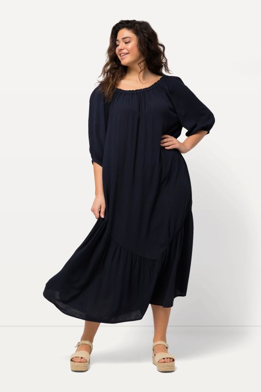 Robe midi à col rond et manches courtes. Base volantée et matière texturée