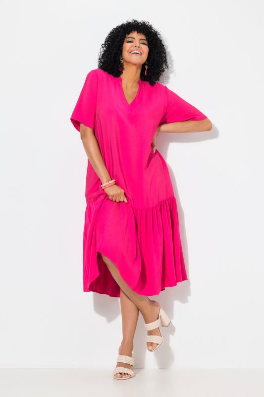 Robe midi, coupe évasée. Manches courtes et col en V. Volant à la base