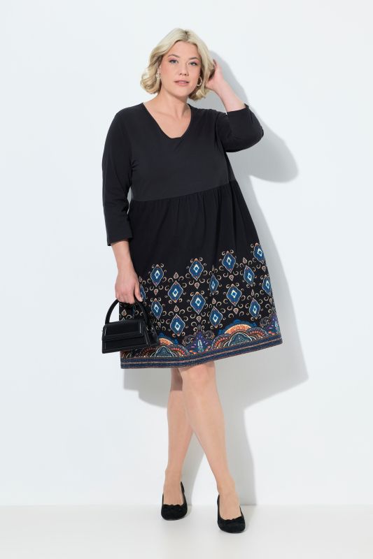 Robe en jersey, coupe évasée et poches. Col en V et manches 3/4