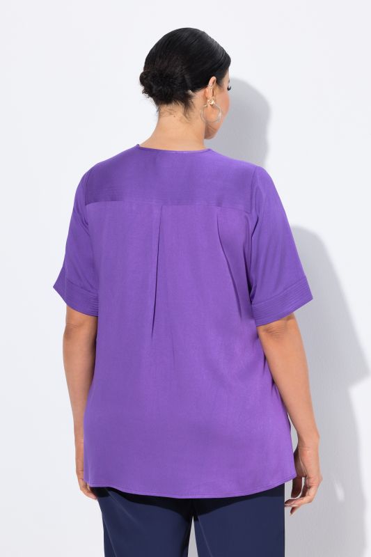 Blouse à empiècement matelassé. Manches courtes et coupé évasée
