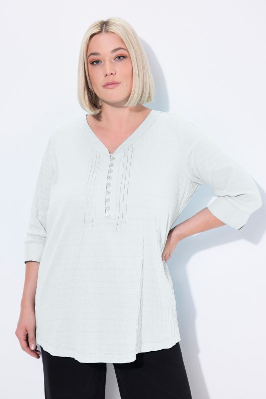 Tunique en tissu gaufré. Manches 3/4. Décolleté cœur et plis fantaisie