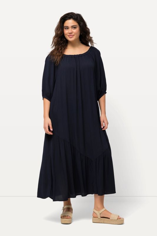 Robe midi à col rond et manches courtes. Base volantée et matière texturée