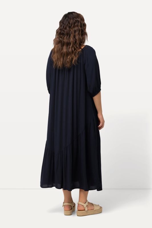 Robe midi à col rond et manches courtes. Base volantée et matière texturée