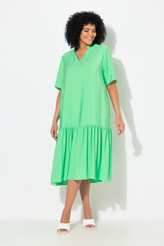 Robe midi, coupe évasée. Manches courtes et col en V. Volant à la base