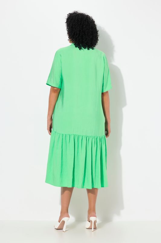 Robe midi, coupe évasée. Manches courtes et col en V. Volant à la base