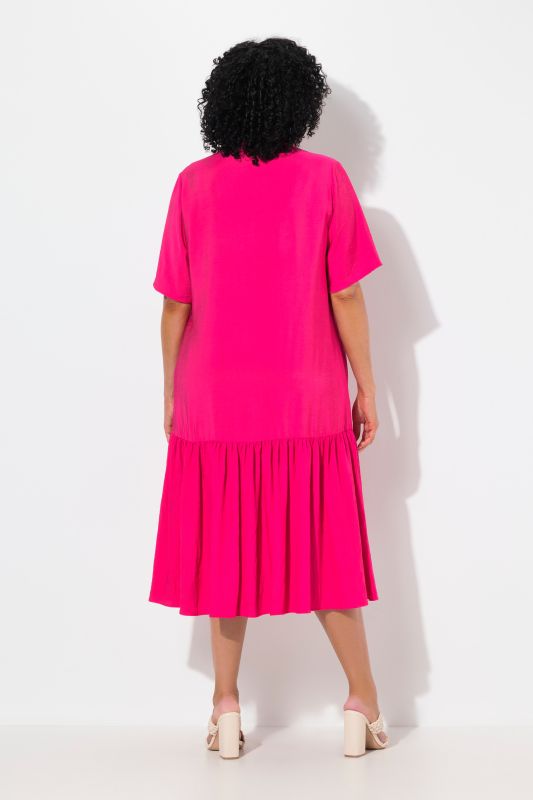 Robe midi, coupe évasée. Manches courtes et col en V. Volant à la base