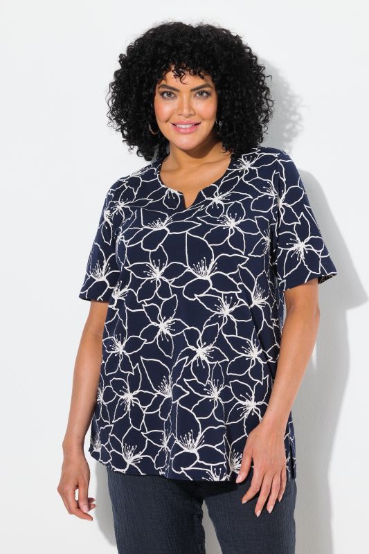 T-shirt à fleurs. Manches courtes et col tunisien. Coupe évasée