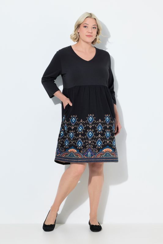 Robe en jersey, coupe évasée et poches. Col en V et manches 3/4