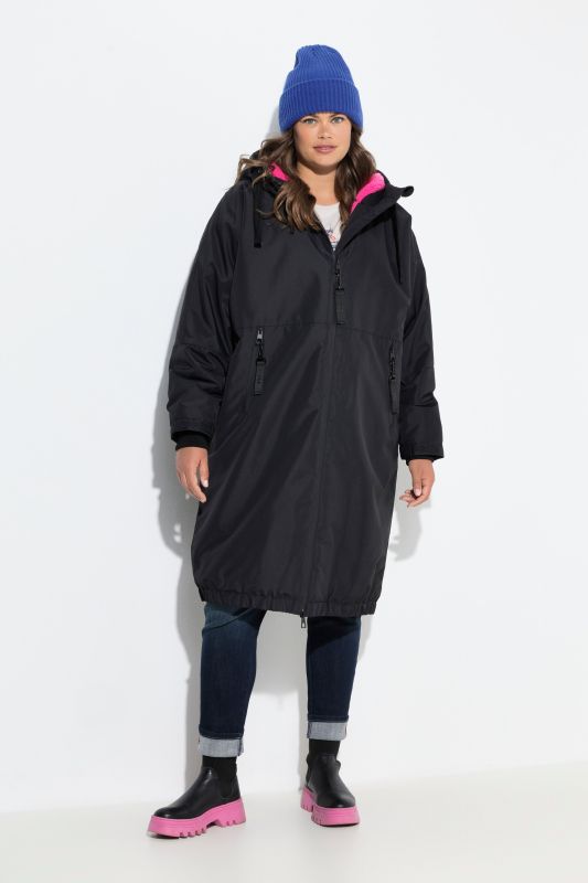Veste technique oversize à capuche. Doublure polaire bouclée. Fermeture éclair à double sens
