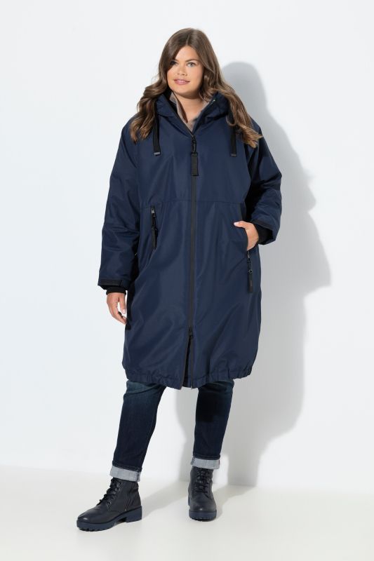 Veste technique oversize à capuche. Doublure polaire bouclée. Fermeture éclair à double sens