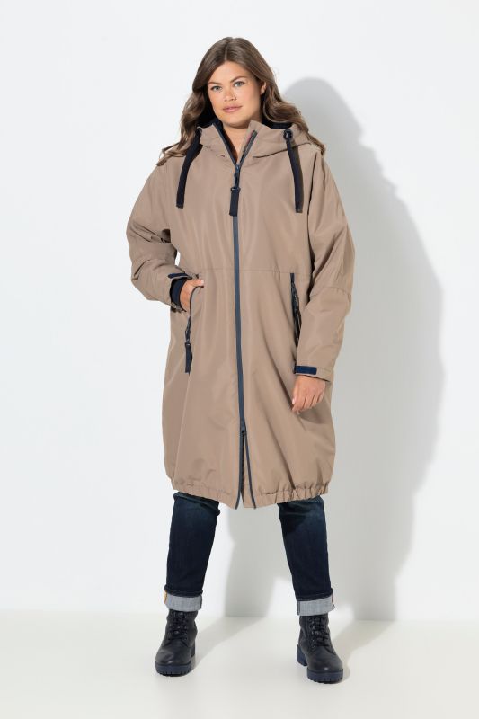 Veste technique oversize à capuche. Doublure polaire bouclée. Fermeture éclair à double sens