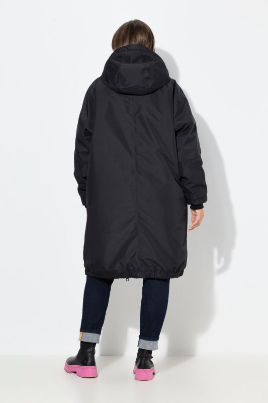 Veste technique oversize à capuche. Doublure polaire bouclée. Fermeture éclair à double sens