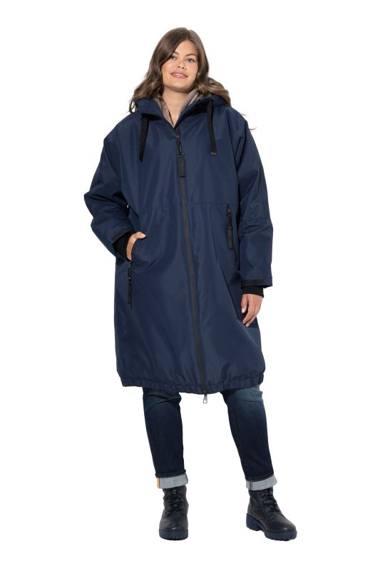 Veste technique oversize à capuche. Doublure polaire bouclée. Fermeture éclair à double sens