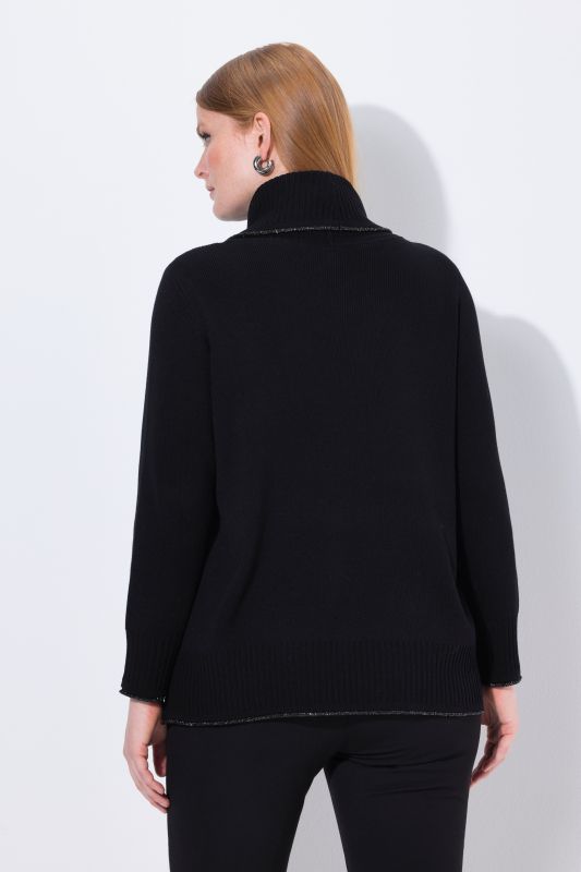 Pull à manches longues et bord roulé pailleté. Coupe évasée et col roulé