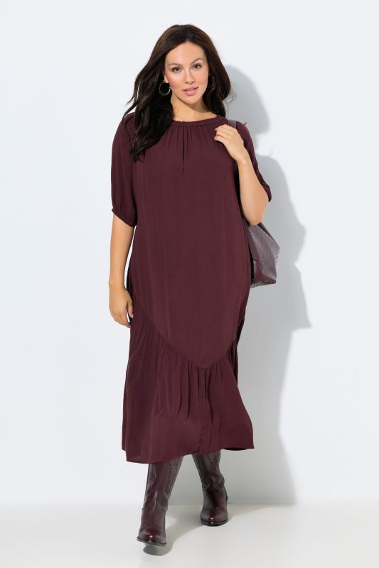 Robe midi à col rond et manches courtes. Base volantée et matière texturée