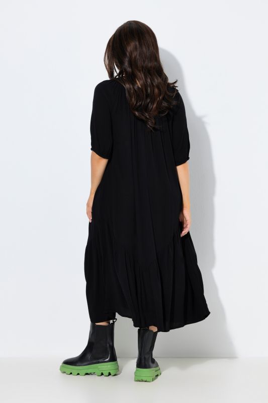 Robe midi à col rond et manches courtes. Base volantée et matière texturée
