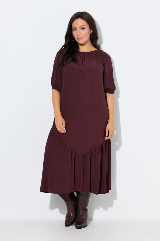 Robe midi à col rond et manches courtes. Base volantée et matière texturée