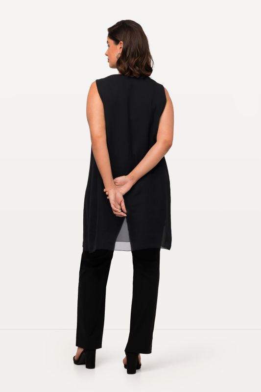 Tunique longue, sans manches. Coupe évasée. Décolleté rond à pierres fantaisie