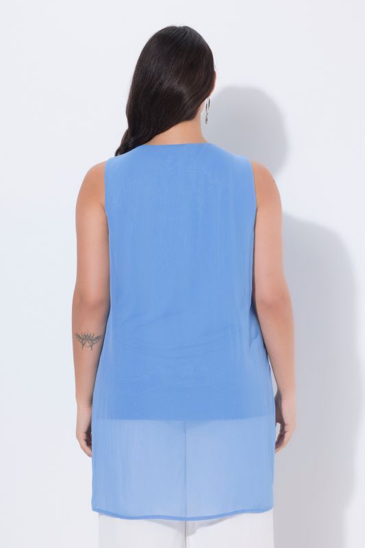 Tunique longue, sans manches. Coupe évasée. Décolleté rond à pierres fantaisie