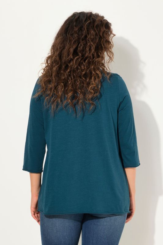 T-shirt col en V et manches longues. Motif cœur et coupe évasée.