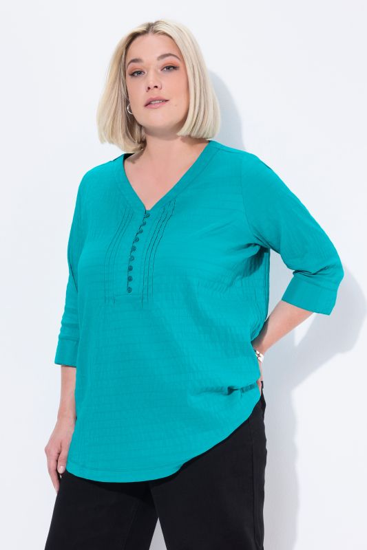 Tunique en tissu gaufré. Manches 3/4. Décolleté cœur et plis fantaisie