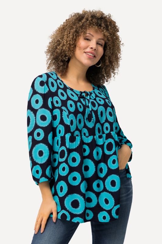 Blouse smockée à motif cercles. Col rond et manches 3/4. Coupe évasée