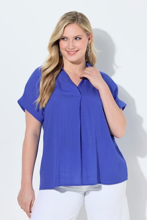 Blouse à manches courtes, boutons dans le dos et pli fantaisie. Coupe oversize.