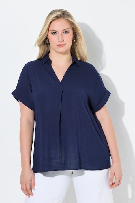 Blouse à manches courtes, boutons dans le dos et pli fantaisie. Coupe oversize.