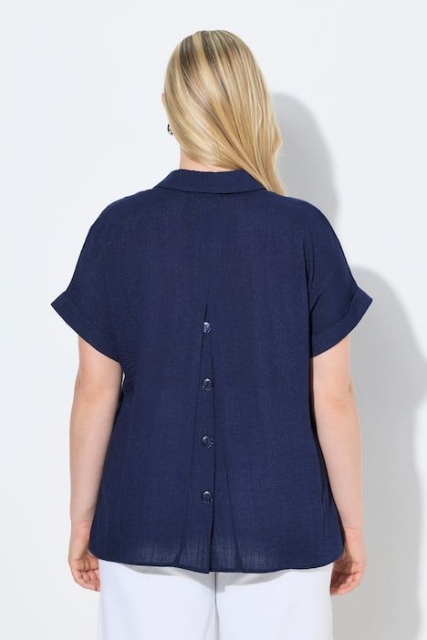 Blouse à manches courtes, boutons dans le dos et pli fantaisie. Coupe oversize.