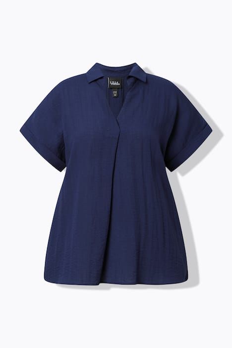 Blouse à manches courtes, boutons dans le dos et pli fantaisie. Coupe oversize.