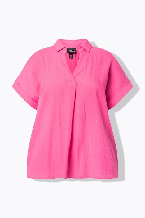 Blouse à manches courtes, boutons dans le dos et pli fantaisie. Coupe oversize.