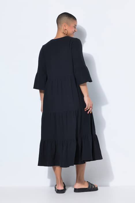 Robe maxi en mousseline, à col montant, manches 3/4 et volants. Coupe trapèze