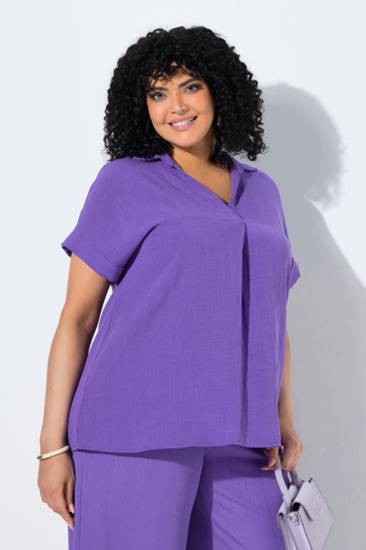 Blouse à manches courtes, boutons dans le dos et pli fantaisie. Coupe oversize.
