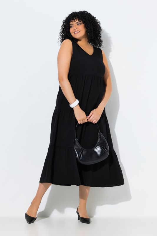 Robe maxi sans manches. Plusieurs niveaux de volants. Décolleté V. Coupe évasée