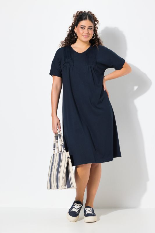 Robe en jersey à plis fantaisie. Col V et manches courtes. Coupe évasée