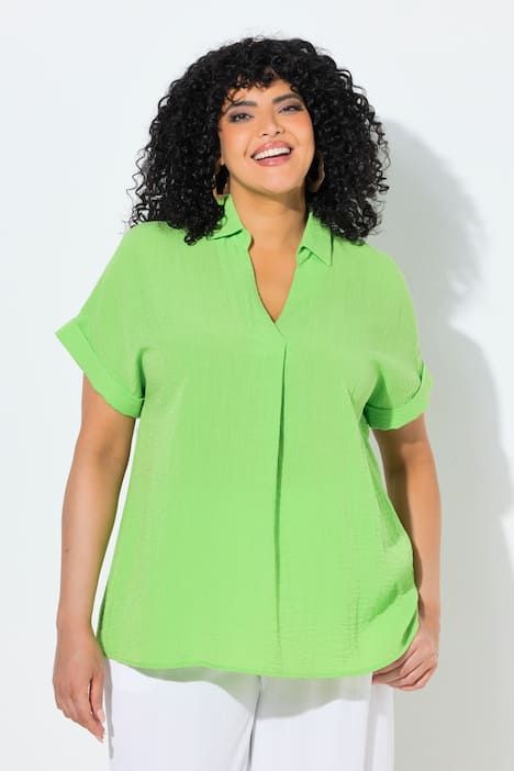 Blouse à manches courtes, boutons dans le dos et pli fantaisie. Coupe oversize.