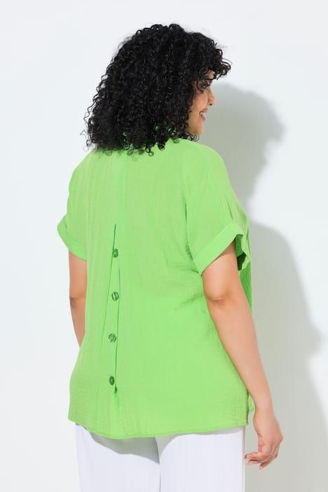 Blouse à manches courtes, boutons dans le dos et pli fantaisie. Coupe oversize.