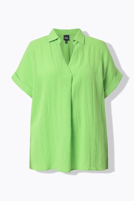 Blouse à manches courtes, boutons dans le dos et pli fantaisie. Coupe oversize.