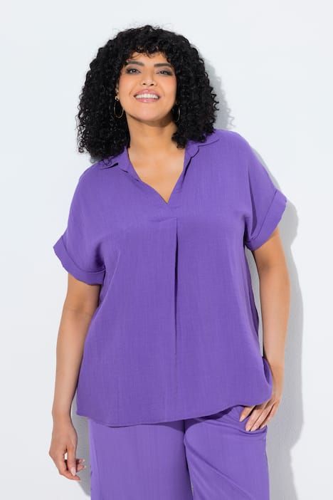 Blouse à manches courtes, boutons dans le dos et pli fantaisie. Coupe oversize.