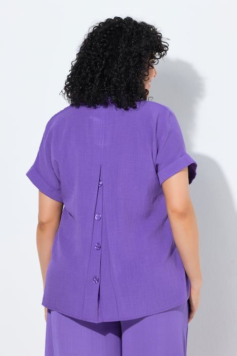 Blouse à manches courtes, boutons dans le dos et pli fantaisie. Coupe oversize.