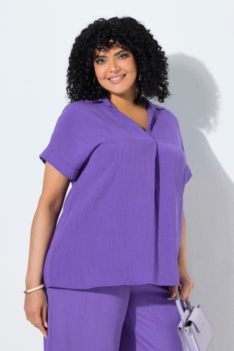 Blouse à manches courtes, boutons dans le dos et pli fantaisie. Coupe oversize.