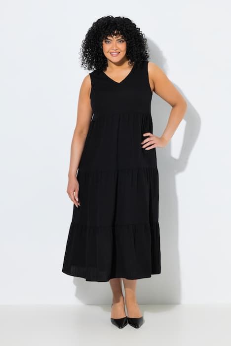 Robe maxi sans manches. Plusieurs niveaux de volants. Décolleté V. Coupe évasée