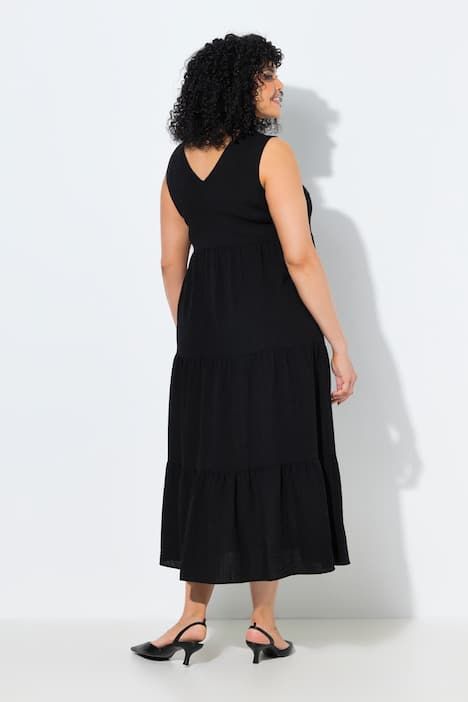 Robe maxi sans manches. Plusieurs niveaux de volants. Décolleté V. Coupe évasée